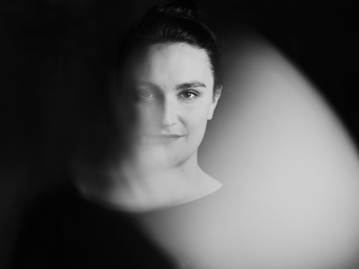 Schwarz-Weiss Aufnahme von Simone Felber. Sie schaut direkt in die Kamera nit einem leichten Lächeln in Gesicht.